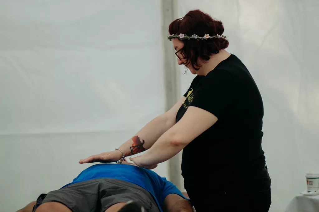 a woman performing Reiki on a man lying down
